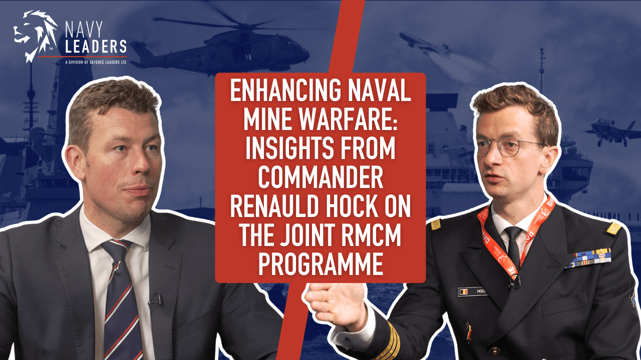 Two men in business attire are shown discussing naval mine warfare. Text reads, "Enhancing Naval Mine Warfare: Insights from Commander Renauld Hock on the Joint RMCM Programme." Background features a naval ship and helicopter.
