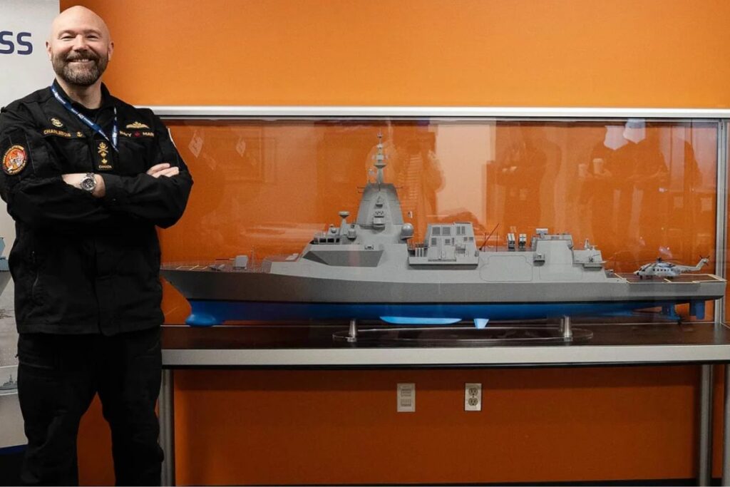 Deputy Commander of the Royal Canadian Navy, Rear-Admiral Charlebois, alongside a detailed scale model of the RCN’s new River-class destroyer.
