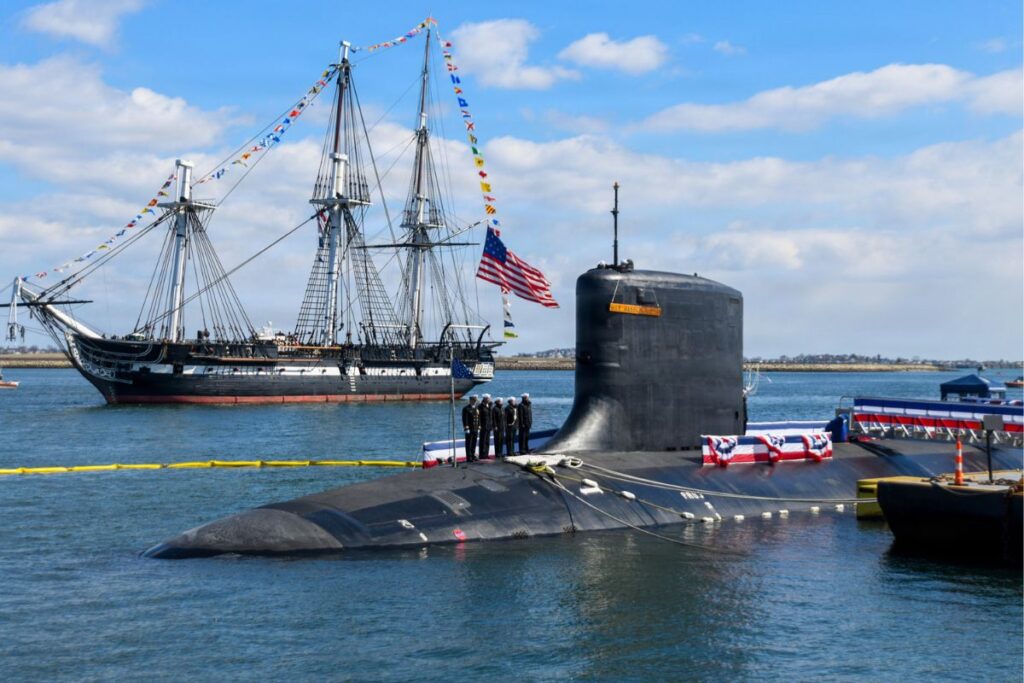 Sailing ship USS Constitution passes Virginia-class nuclear-powered fast-attack boat USS Massachusetts during the new submarine’s commissioning ceremony in Boston.