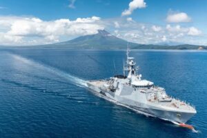 Royal Navy Batch II River-class offshore patrol vessel HMS Spey sailing off the coast of Mayotte with Mount Choungui in the background in 2023.