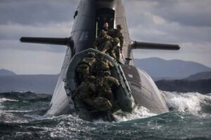 Hitching a lift — Royal Marines riding a German submarine off Cape Wrath on Exercise Strike Warrior.