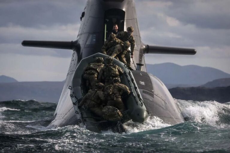 Hitching a lift — Royal Marines riding a German submarine off Cape Wrath on Exercise Strike Warrior.
