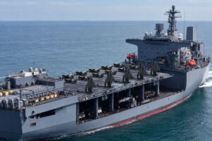 An AI-generated impression of X-BAT VTOL uncrewed fighter aircraft deployed on an amphibious assault ship.