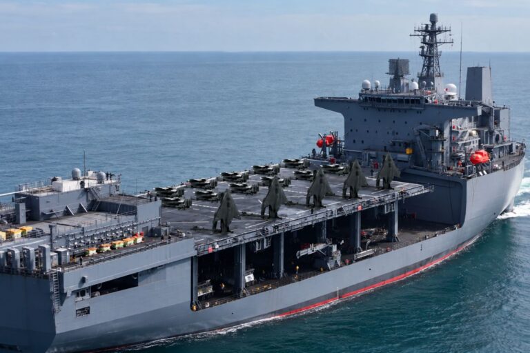 An AI-generated impression of X-BAT VTOL uncrewed fighter aircraft deployed on an amphibious assault ship.